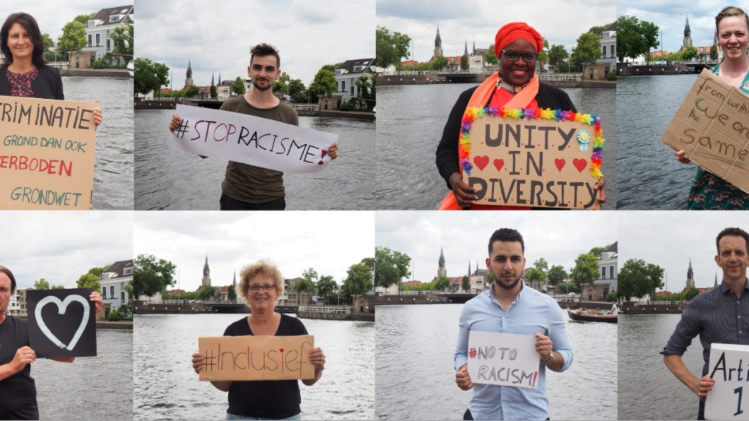 De fractieleden van GroenLinks Delft tonen de protestborden die zij hebben gemaakt om zich tegen racisme uit te spreken